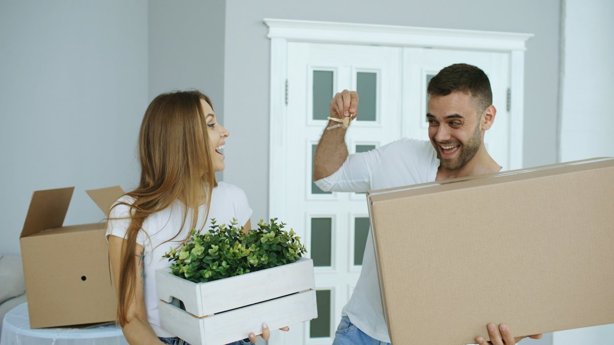 Couple holding keys to their new home on moving day