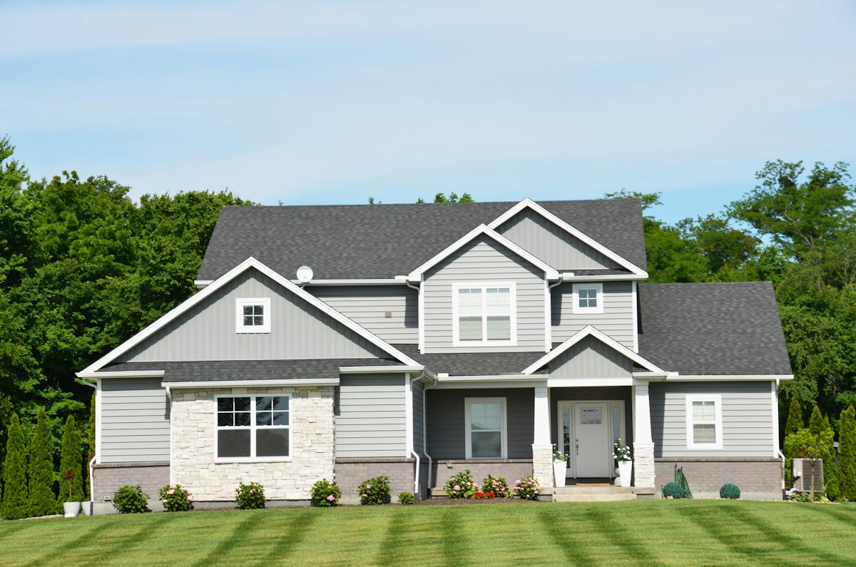 Gray two-story suburban family home on a sunny street